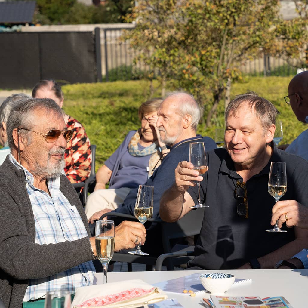 Bewoners klinken op de zomer in de tuin van Gaudium assistentiewoningen in Mol